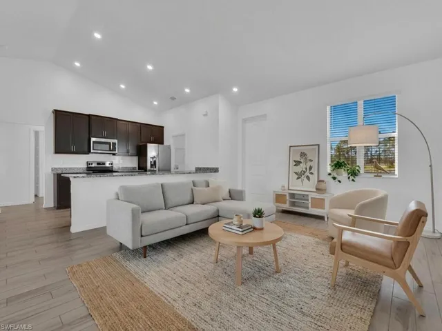 Living room featuring lofted ceiling, light wood finished floors, and recessed lighting