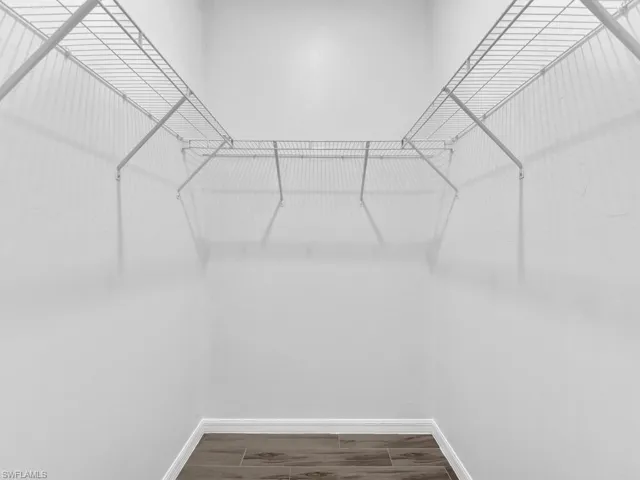 Walk in closet with wood finish floors