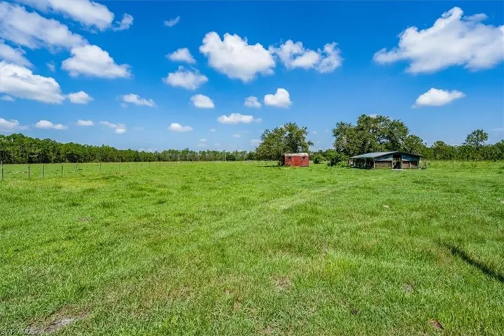 Field with storage shed and pole barn
