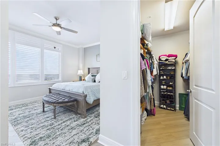Bedroom with ornamental molding, light wood-type flooring, and a ceiling fan