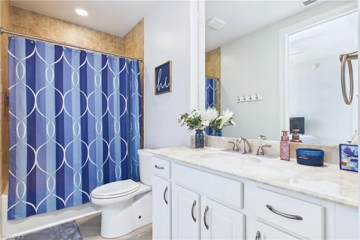 Ensuite bathroom featuring vanity, recessed lighting, and shower / tub combo