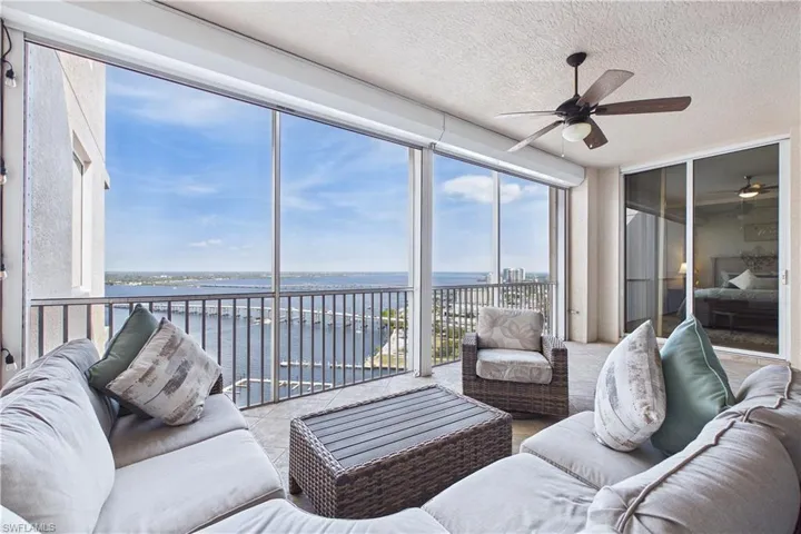 Sunroom featuring a water view and a textured ceiling