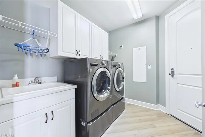 Laundry area featuring cabinet space, separate washer and dryer, and light wood-style flooring