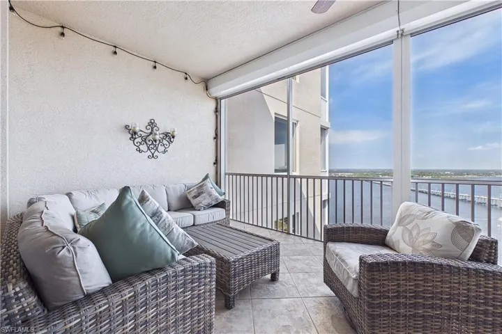 Sunroom / solarium with a balcony, outdoor furniture, and a water view