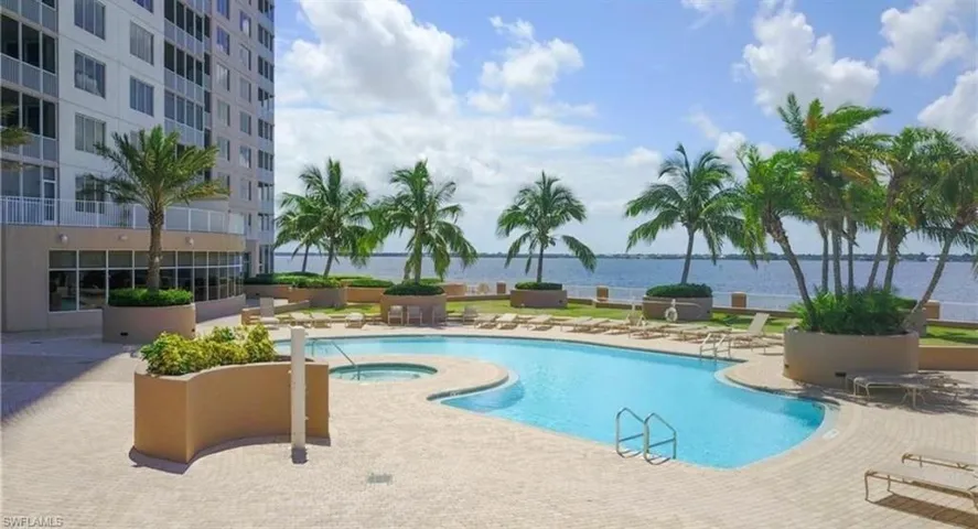 Community pool featuring a community hot tub, a water view, and a patio