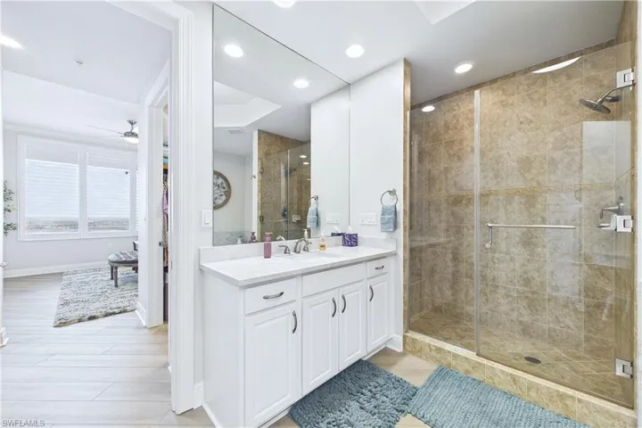 Full bathroom with vanity, a stall shower, light wood-type flooring, ceiling fan, and recessed lighting