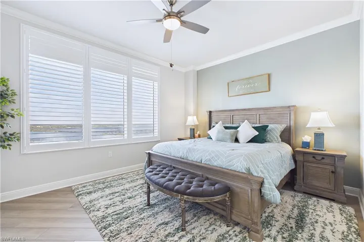 Bedroom featuring crown molding, a ceiling fan, and light wood finished floors