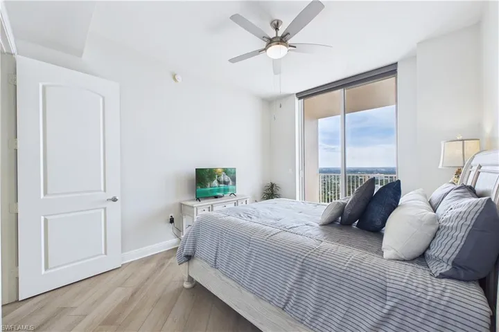 Bedroom with wood finished floors, access to outside, and ceiling fan