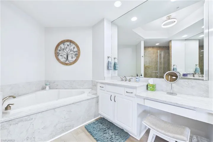 Full bath with vanity, a stall shower, a garden tub, recessed lighting, and light wood finished floors