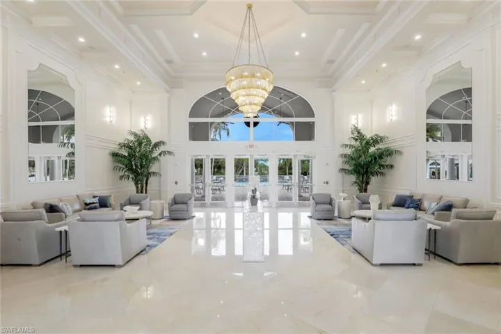 Living room featuring a high ceiling, ornamental molding, an inviting chandelier, and french doors