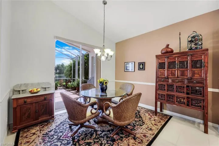Dining area featuring a wealth of natural light, vaulted ceiling, and a notable chandelier
