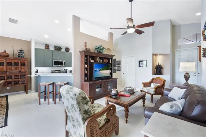 Tiled living room with high vaulted ceiling and ceiling fan