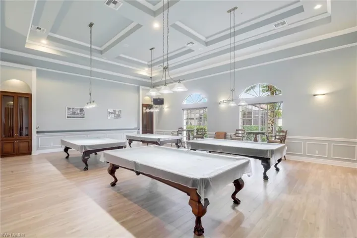 Recreation room with a high ceiling, coffered ceiling, billiards, and light hardwood / wood-style floors