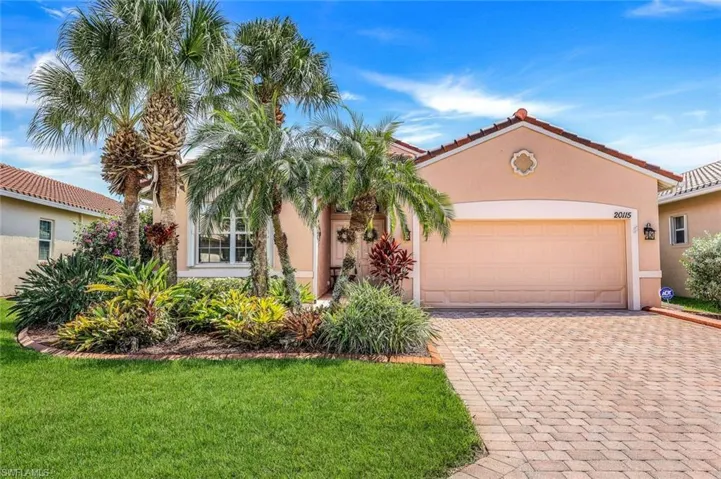 Mediterranean / spanish home with a front yard and a garage