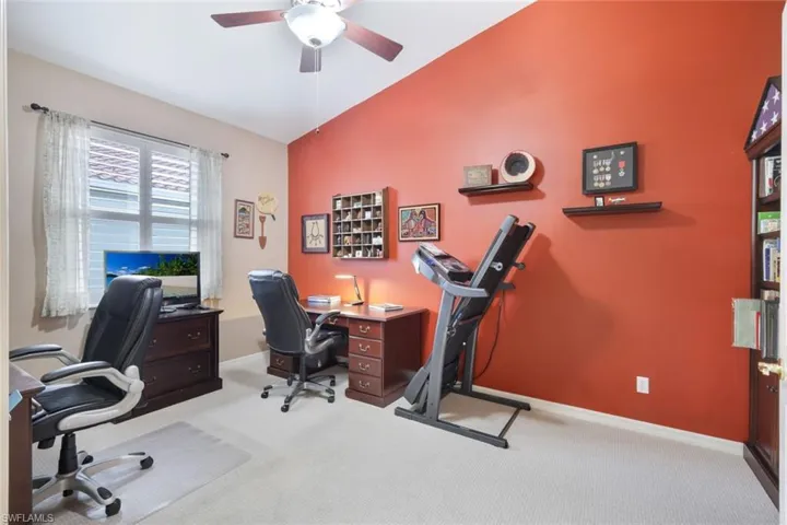 Carpeted office featuring lofted ceiling and ceiling fan