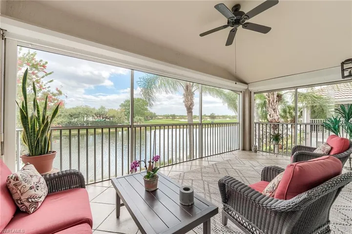 Sunroom with a water view and a ceiling fan
