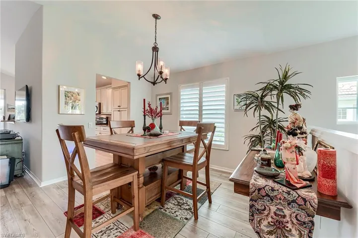 Dining area featuring baseboards, light wood-style floors, and a chandelier