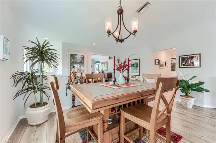 Dining room with an inviting chandelier, light wood-type flooring, baseboards, and visible vents