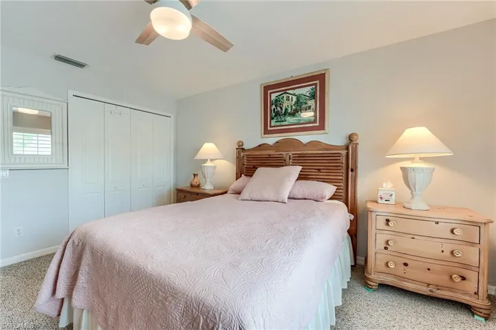 Bedroom featuring a closet, light carpet, baseboards, visible vents, and ceiling fan