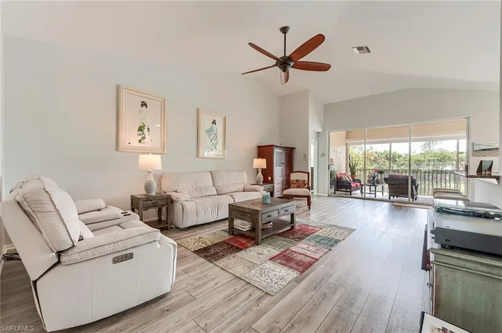 Living room featuring a ceiling fan, light wood-style floors, lofted ceiling, and visible vents