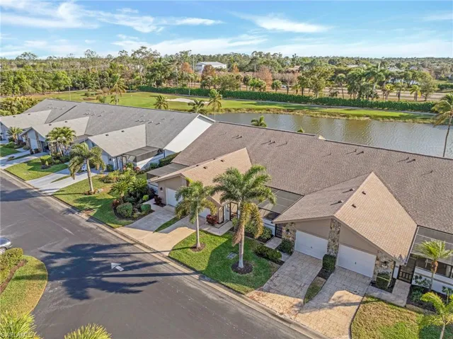 Aerial perspective of suburban area with a large body of water and a golf course