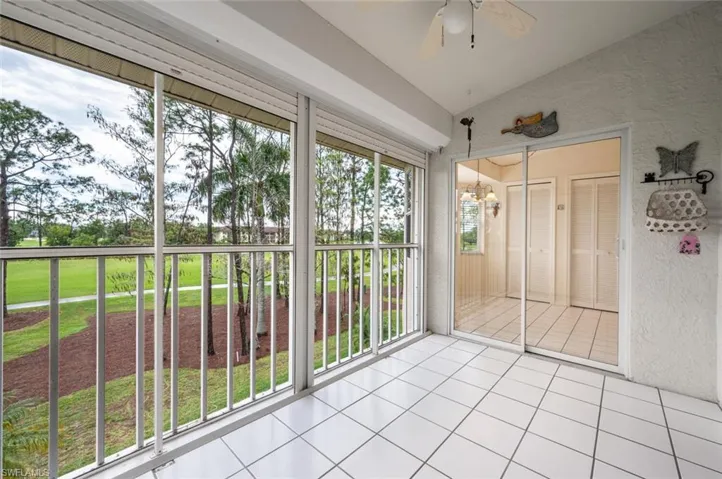 Unfurnished sunroom featuring ceiling fan with notable chandelier and vaulted ceiling