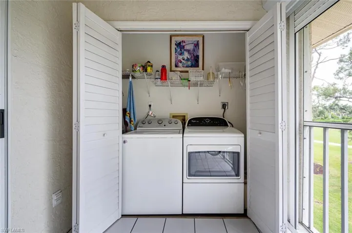 Laundry room with light tile patterned floors and separate washer and dryer