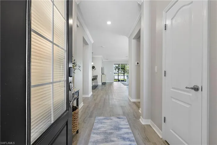 Hall featuring light wood-type flooring and crown molding
