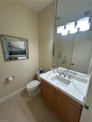 Half bath featuring vanity and light tile patterned floors