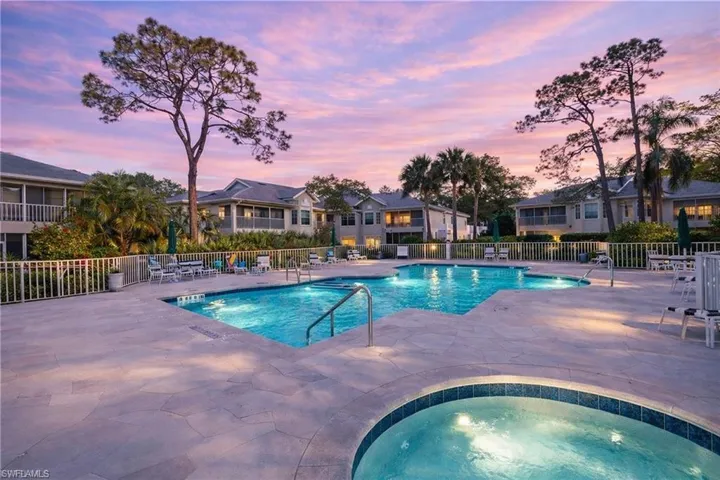 Pool at dusk with a patio, a community pool, a community hot tub, and a residential view