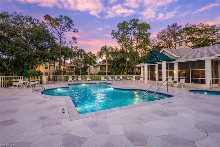 Pool at dusk featuring a patio area and a community pool