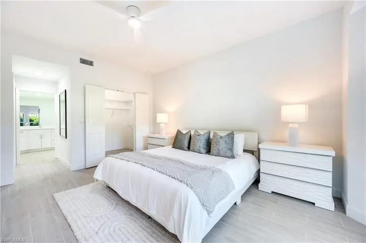 Bedroom featuring a closet, a ceiling fan, wood finish floors, and ensuite bath