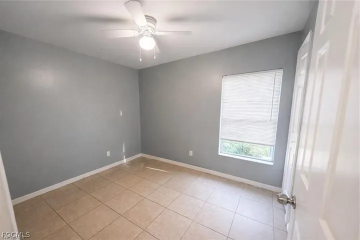 Spare room with a ceiling fan and light tile patterned floors