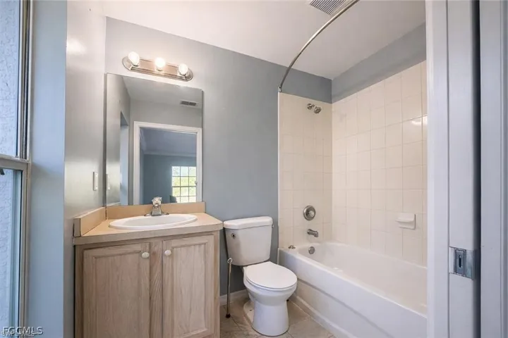Full bath with vanity,  shower combination, and light tile patterned floors