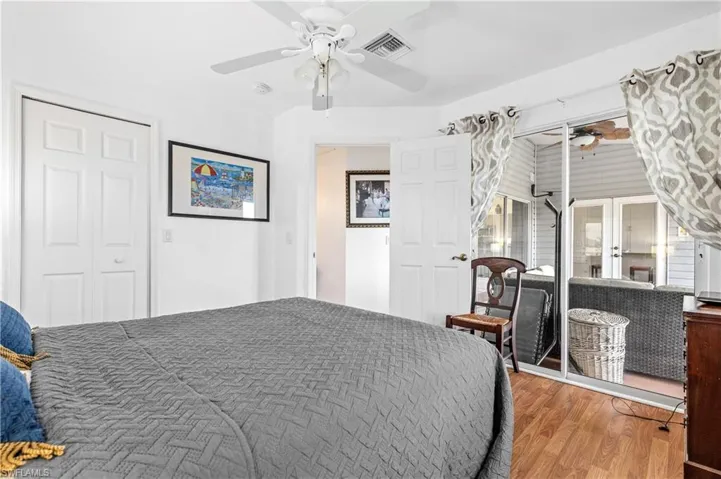 Bedroom with wood finished floors, a ceiling fan, a closet, and french doors