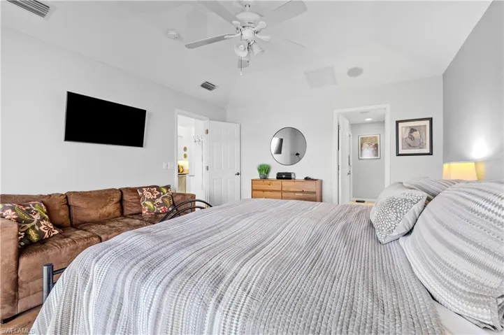 Bedroom featuring a ceiling fan and lofted ceiling