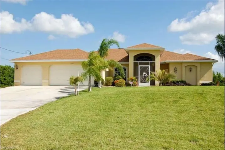 Mediterranean / spanish home with a front lawn, driveway, and stucco siding