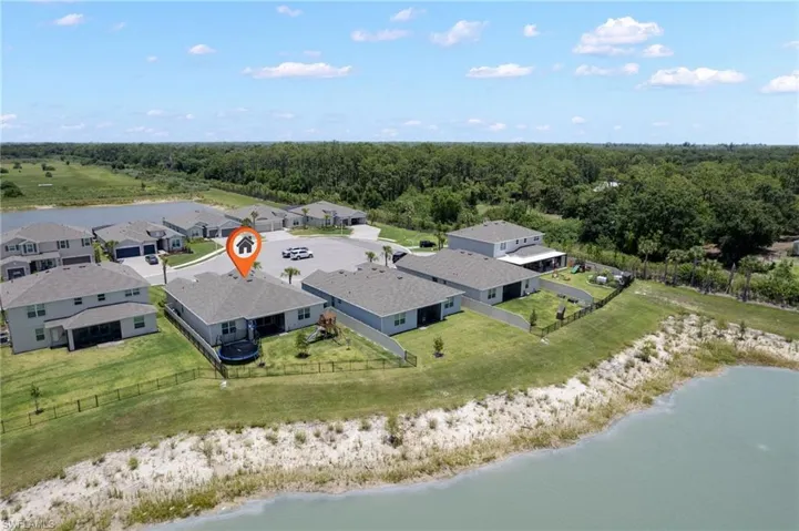 Single-story home with a fenced backyard, featuring a screened lanai and direct water frontage