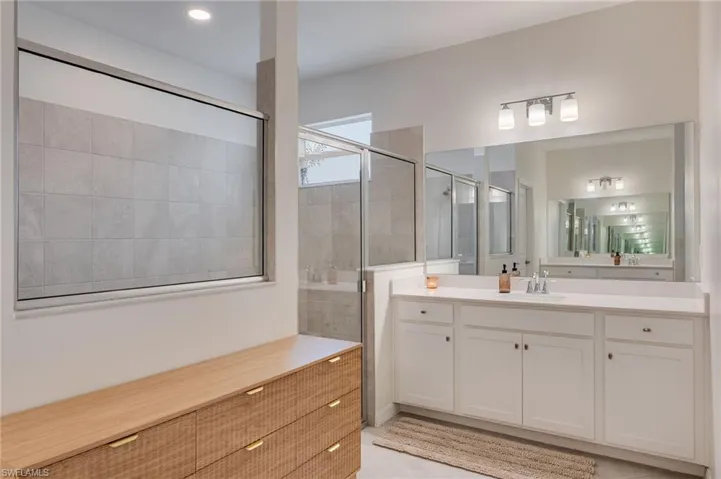 Spacious bathroom featuring a double vanity with white cabinetry and a full-width mirror