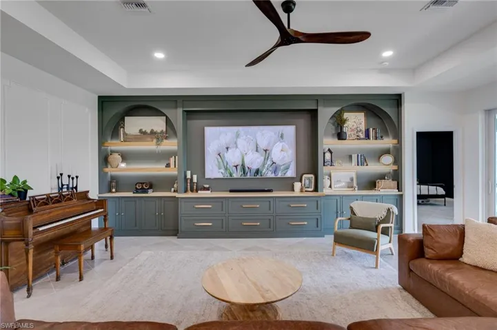 Built-in entertainment center featuring custom cabinetry, integrated shelving, and recessed lighting