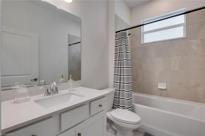 Bathroom featuring a white vanity with an integrated sink, polished chrome faucet, and a large wall-mounted mirror