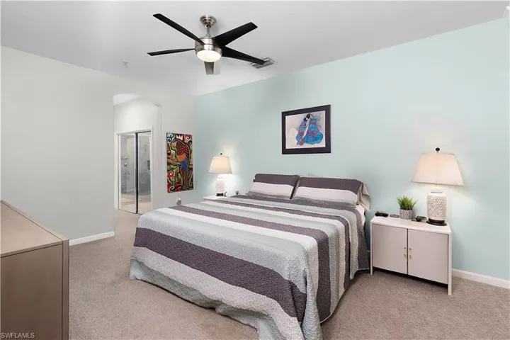 Carpeted bedroom featuring ceiling fan