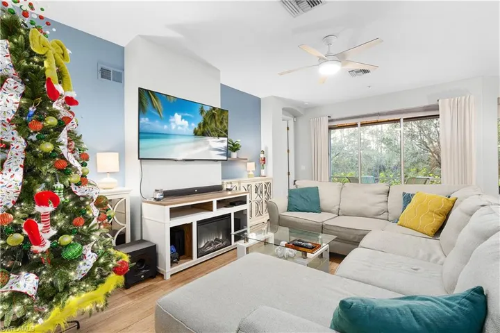 Living room with ceiling fan and light hardwood / wood-style floors
