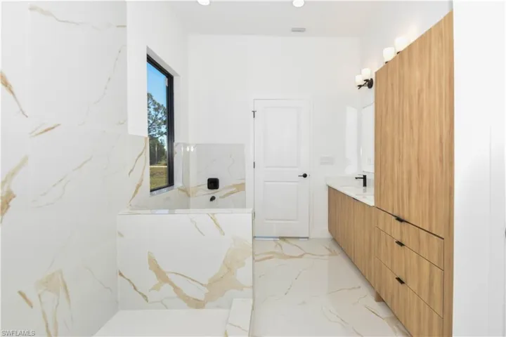 Primary Bathroom featuring vanity, tub, and recessed lighting