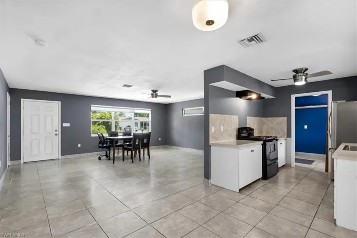 Open-concept living area with tile flooring and a ceiling fan