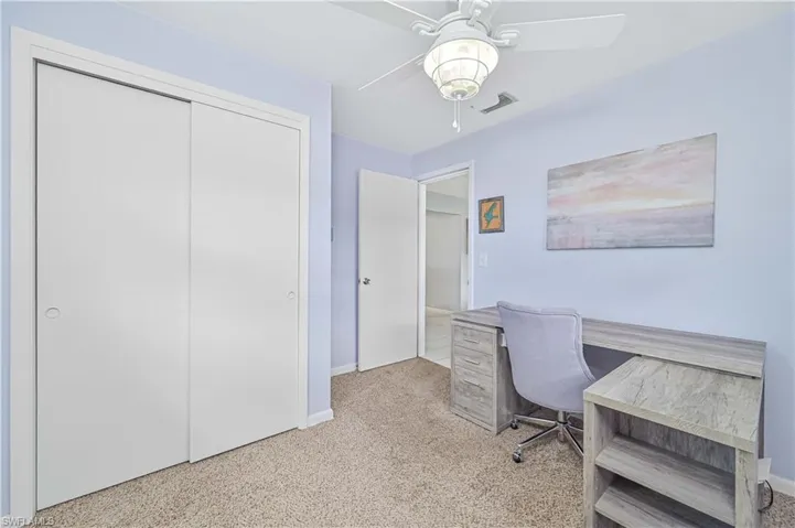 Office space featuring light colored carpet and ceiling fan