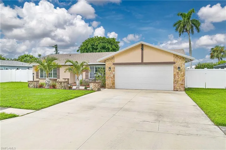 Ranch-style home with stucco siding, concrete driveway, stone siding, and an attached garage