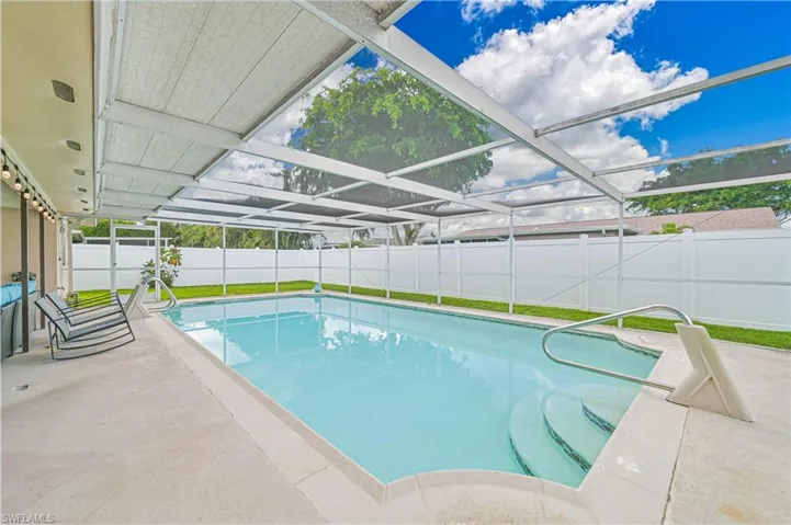 View of swimming pool featuring glass enclosure, a patio, a sunroom, and a fenced backyard