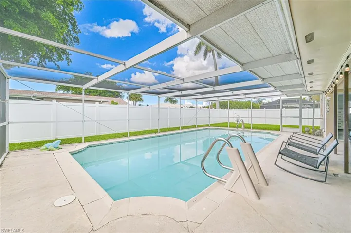 View of swimming pool featuring a sunroom, glass enclosure, a patio area, and a fenced backyard