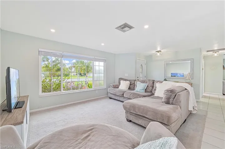 Carpeted living room featuring recessed lighting and baseboards